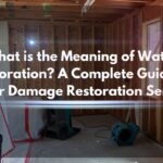 A professional water damage restoration services team using industrial equipment to dry and repair a flooded room.